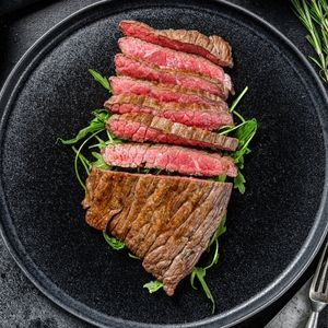 a sliced patio steak on top of a bed of lettuce to show what is a patio steak
