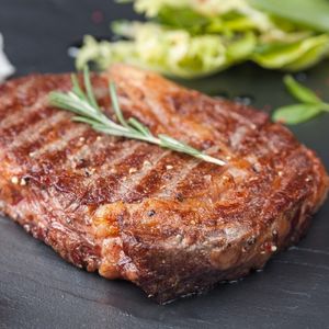 cooked spencer steak with a sprig of rosemary to show what is spencer steak